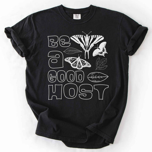 Black "Be a good host" t-shirt on Comfort colors with illustrations of zebra swallowtail and host plant paw paw leaf, spicebush swallowtail and one of its host plants sassafras leaf, and monarch and host plant milkweed leaf. Gift for wildlife gardeners and native plant enthusiasts.