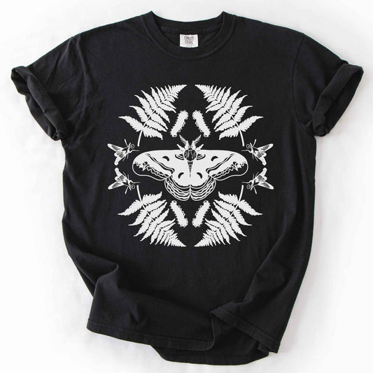 Black "Cecropia moth" t-shirt on Comfort Colors tee, featuring a bold black symmetrical design of a moth surrounded by ferns and hummingbird moths in a mirrored botanical pattern. Nature lover and moth enthusiast gift shirt for entomology and cottagecore fans.