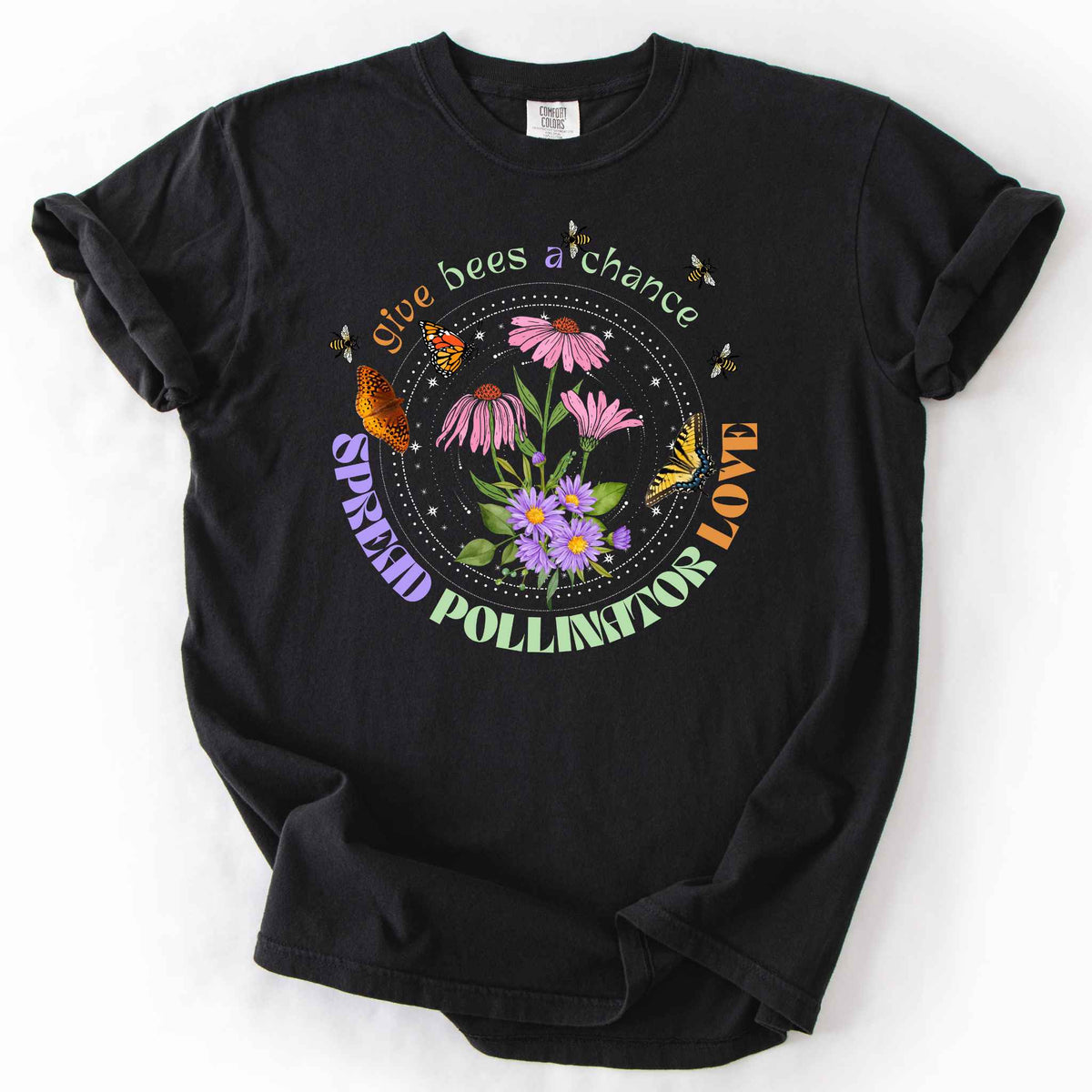 Black "Give Bees a Chance, Spread Pollinator Love" t-shirt on Comfort Colors tee, featuring colorful wildflowers, bees, and butterflies in a celestial circle design — gardener and nature lover gift shirt for bee and pollinator conservation fans.