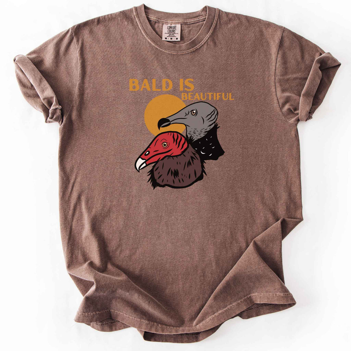 Espresso "Bald Is Beautiful" t-shirt on Comfort Colors tee, featuring illustrated turkey vulture and black vulture heads with orange retro sun and orange lettering. Funny birdwatcher gift shirt for vulture and scavenger lovers.
