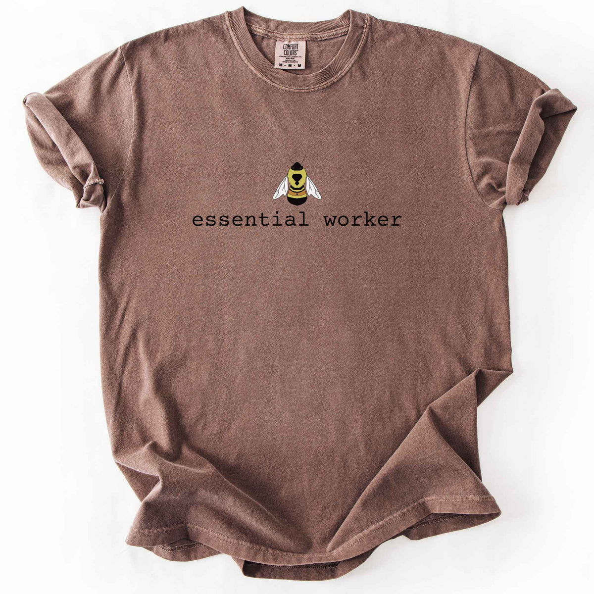 Espresso "Essential Worker" t-shirt on Comfort Colors tee, featuring a small illustrated rusty patch bumblebee above simple typewriter style text. Funny bee lover and pollinator gift shirt for beekeepers and nature enthusiasts.