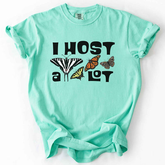 Island reef "I Host a Lot" t-shirt on Comfort Colors tee, featuring four butterfly species graphics including a Zebra Swallowtail and Monarch with bold black lettering text. Funny gardener and butterfly host plant gift shirt for pollinator enthusiasts.