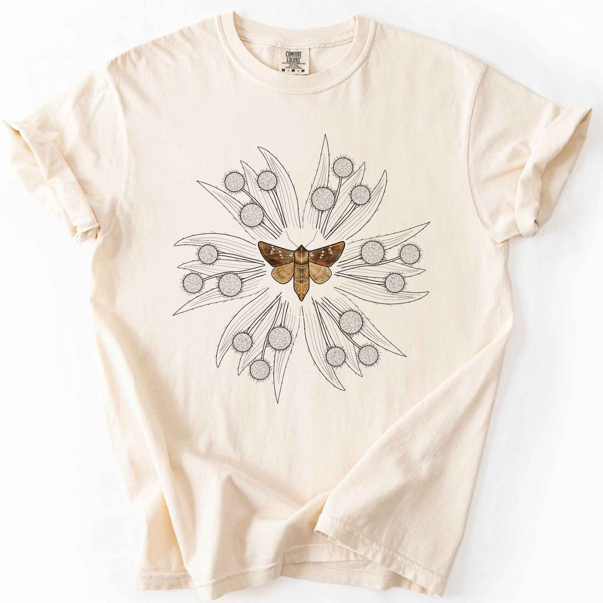 Ivory endangered moth t-shirt on Comfort Colors tee, featuring a realistic Rattlesnake Master Borer Moth (Papaipema eryngii) at the center of a mandala style burst of hand drawn thistle flowers. Nature lover and moth enthusiast gift shirt for entomology and botanical illustration fans.