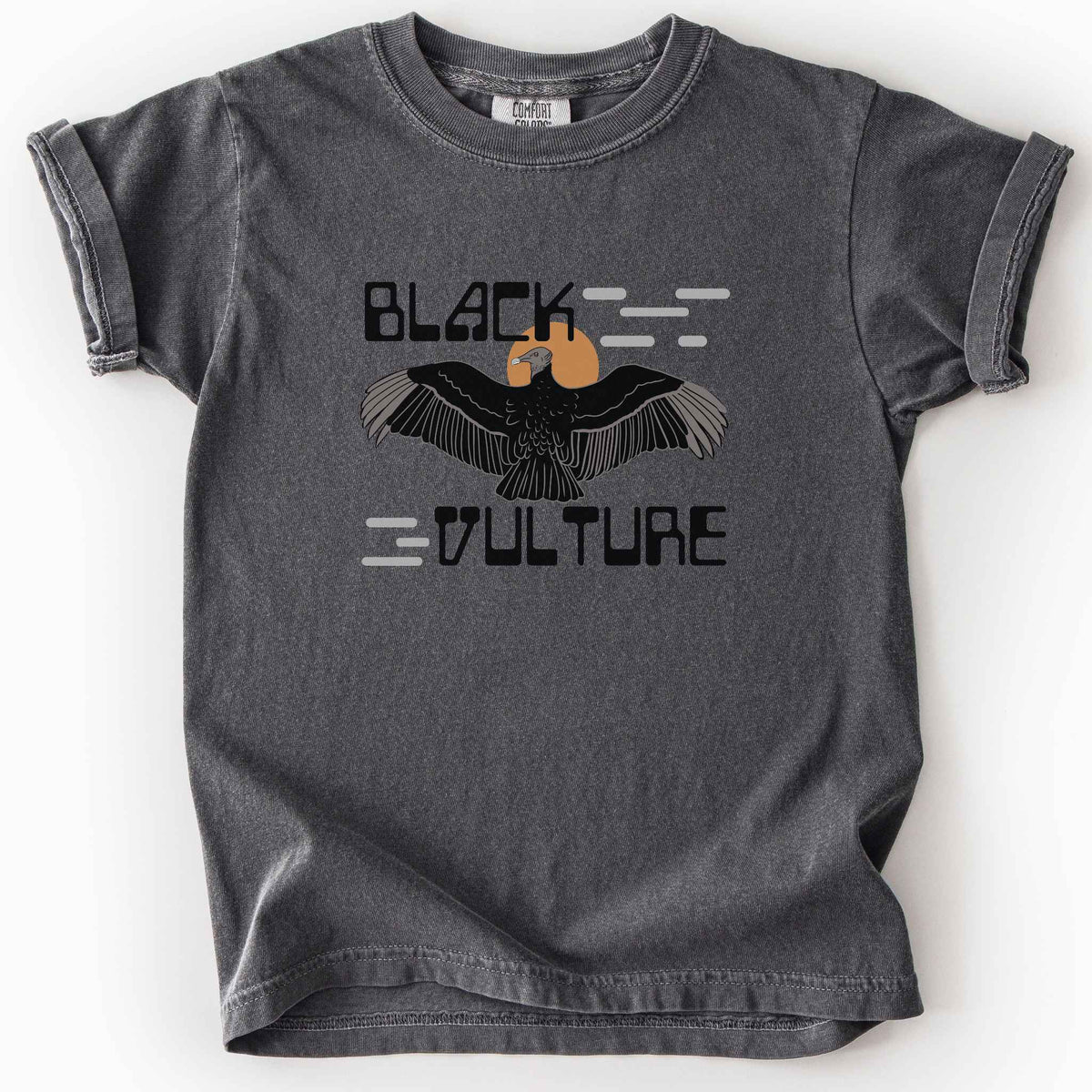 Pepper "Black Vulture" kids t-shirt on Comfort Colors tee, featuring a vulture with spread wings against an orange sun with bold geometric lettering. Birdwatcher and scavenger lover gift shirt for wildlife and nature enthusiasts.