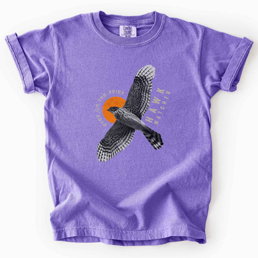 Violet "Hawk Watcher, Eyes on the Skies" t-shirt on Comfort Colors tee, featuring a flying hawk graphic with spread wings against an orange sun design- birdwatching and raptor lover gift shirt for bird enthusiasts.