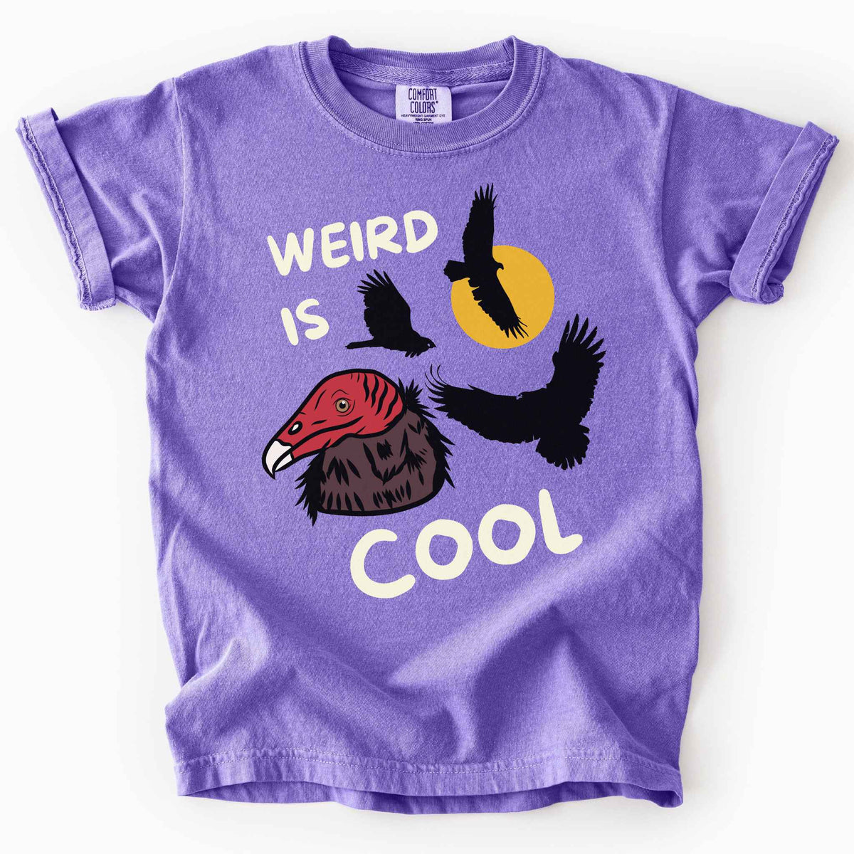 Violet "Weird is cool" kids t-shirt on comfort colors tee featuring turkey vulture silhouettes and a hand-drawn profile graphic with bold white playful text. Gift for little beginning birders and wildlife enthusiasts.