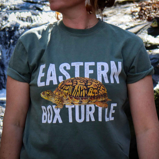 Person wearing a green t-shirt with an illustration of an Eastern Box Turtle and text.