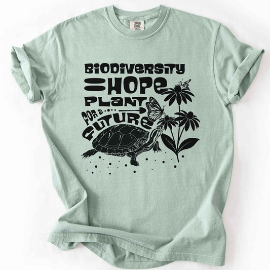 Bay "Biodiversity Hope, Plant for a Future" t-shirt on Comfort Colors tee, featuring a black graphic of a turtle with monarch butterflies on coneflowers in bold groovy lettering. Conservation and native plant gift shirt for wildlife and biodiversity enthusiasts.
