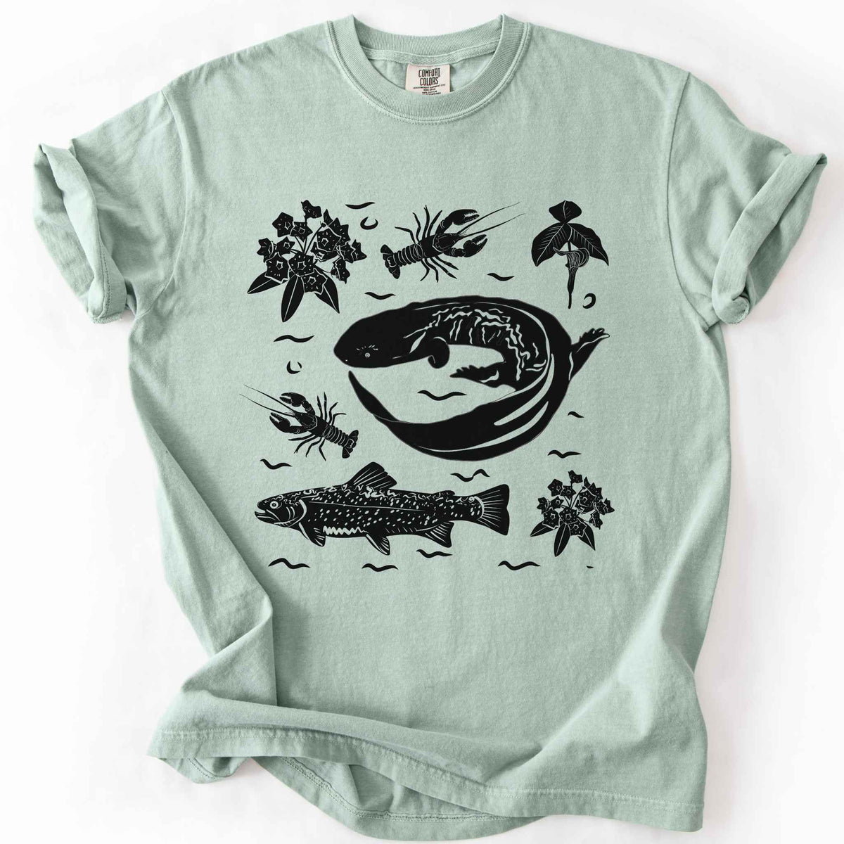 Bay "Hellbender Ecology" t-shirt on Comfort Colors tee, featuring a curled hellbender salamander surrounded by hand-drawn crayfish, trout, and mountain laurel. Amphibian and river ecosystem gift shirt for herpetology and fly fishing enthusiasts.