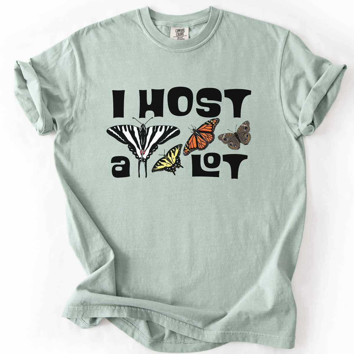 Bay "I Host a Lot" t-shirt on Comfort Colors tee, featuring four butterfly species graphics including a Zebra Swallowtail and Monarch with bold black lettering text. Funny gardener and butterfly host plant gift shirt for pollinator enthusiasts.
