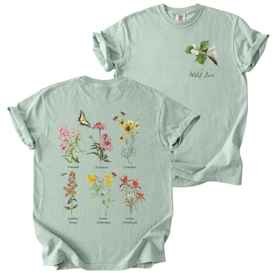Bay "Wild Love" t-shirt on Comfort Colors tee, featuring a small front chest trillium graphic and a full back graphics of six labeled wildflowers including Echinacea, Coreopsis, and Cardinal Flower with bees and a butterfly. Botanical gift shirt for gardeners and native plant enthusiasts.