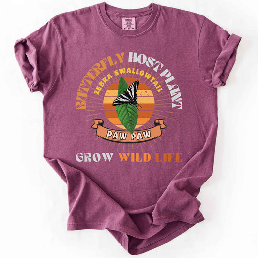 Berry "Butterfly Host Plant, Zebra Swallowtail, Paw Paw, Grow Wild Life" t-shirt on Comfort Colors tee, featuring a zebra swallowtail on a pawpaw leaf against a retro sunburst design with a ribbon banner. Butterfly gardener and native plant gift shirt for pollinator and conservation enthusiasts.