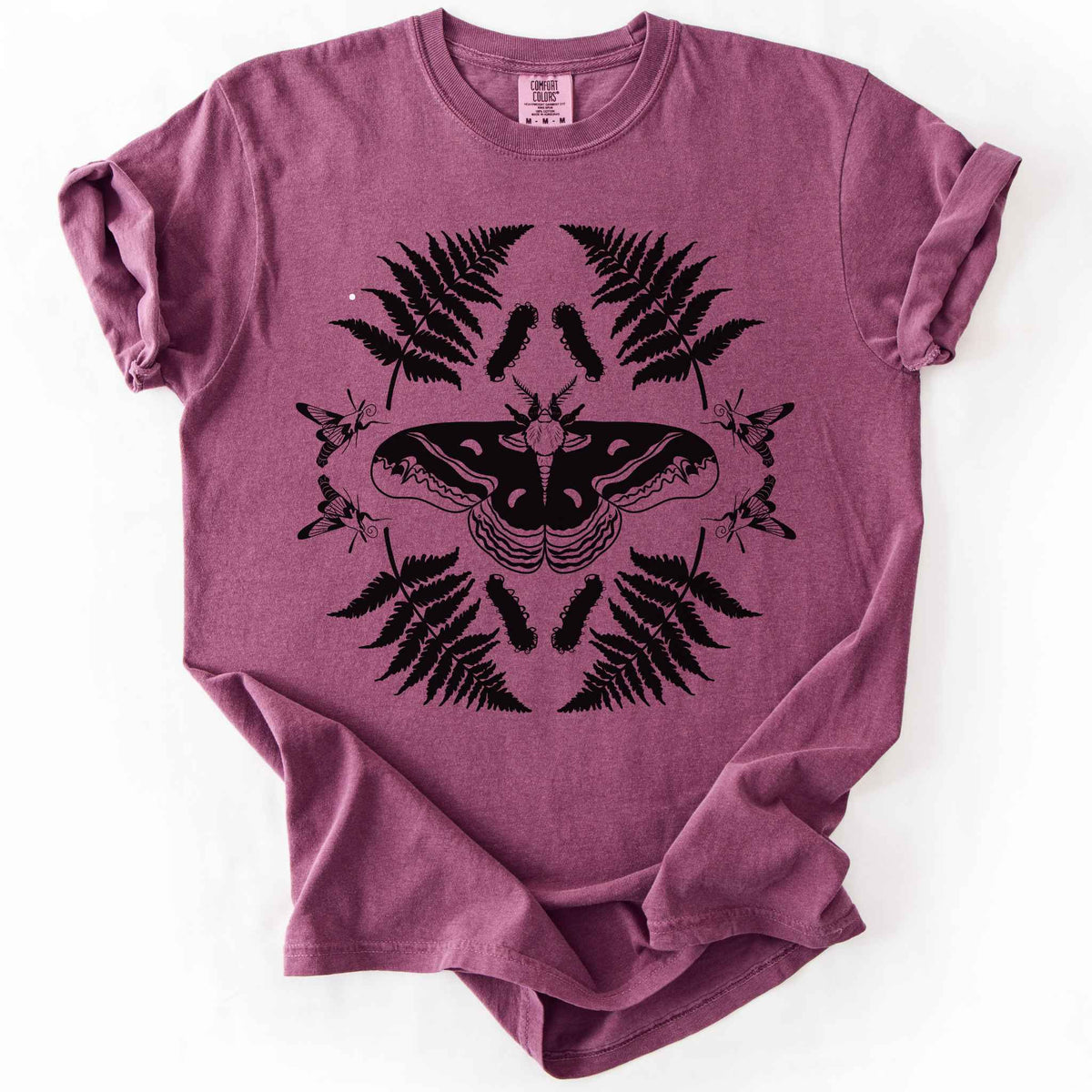 Berry "Cecropia moth" t-shirt on Comfort Colors tee, featuring a bold black symmetrical design of a moth surrounded by ferns and hummingbird moths in a mirrored botanical pattern. Nature lover and moth enthusiast gift shirt for entomology and cottagecore fans.