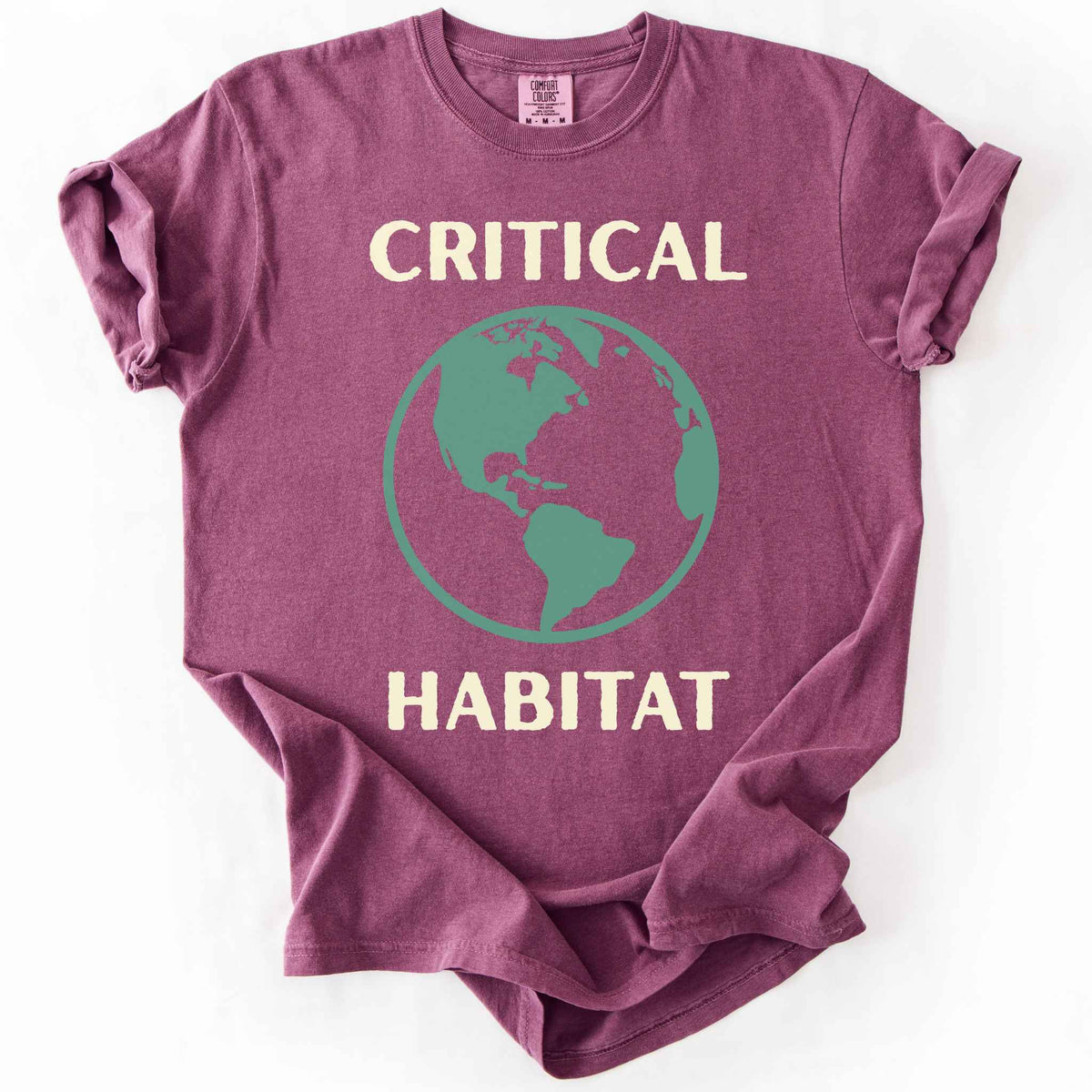 Berry "Critical Habitat" t-shirt on Comfort Colors tee, featuring a bold green globe graphic with cream lettering. Conservation and environmentalist gift shirt for earth science and wildlife protection advocates.