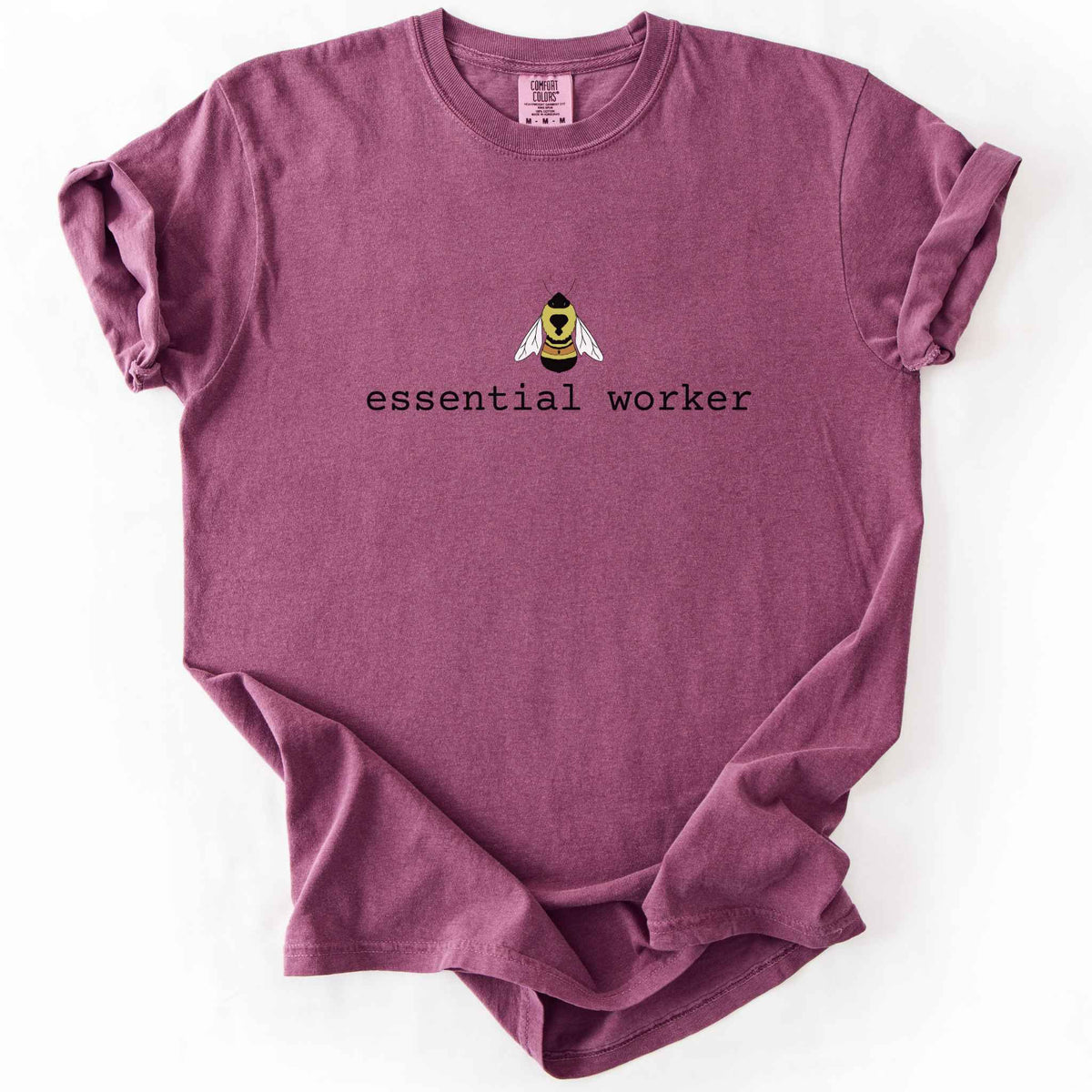 Berry "Essential Worker" t-shirt on Comfort Colors tee, featuring a small illustrated rusty patch bumblebee above simple typewriter style text. Funny bee lover and pollinator gift shirt for beekeepers and nature enthusiasts.