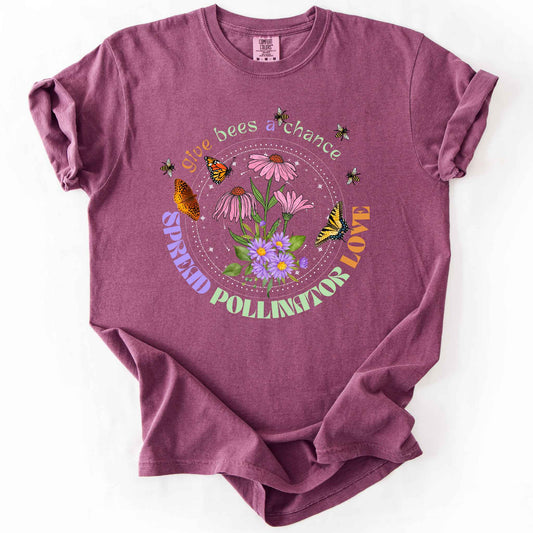 Berry "Give Bees a Chance, Spread Pollinator Love" t-shirt on Comfort Colors tee, featuring colorful wildflowers, bees, and butterflies in a celestial circle design — gardener and nature lover gift shirt for bee and pollinator conservation fans.