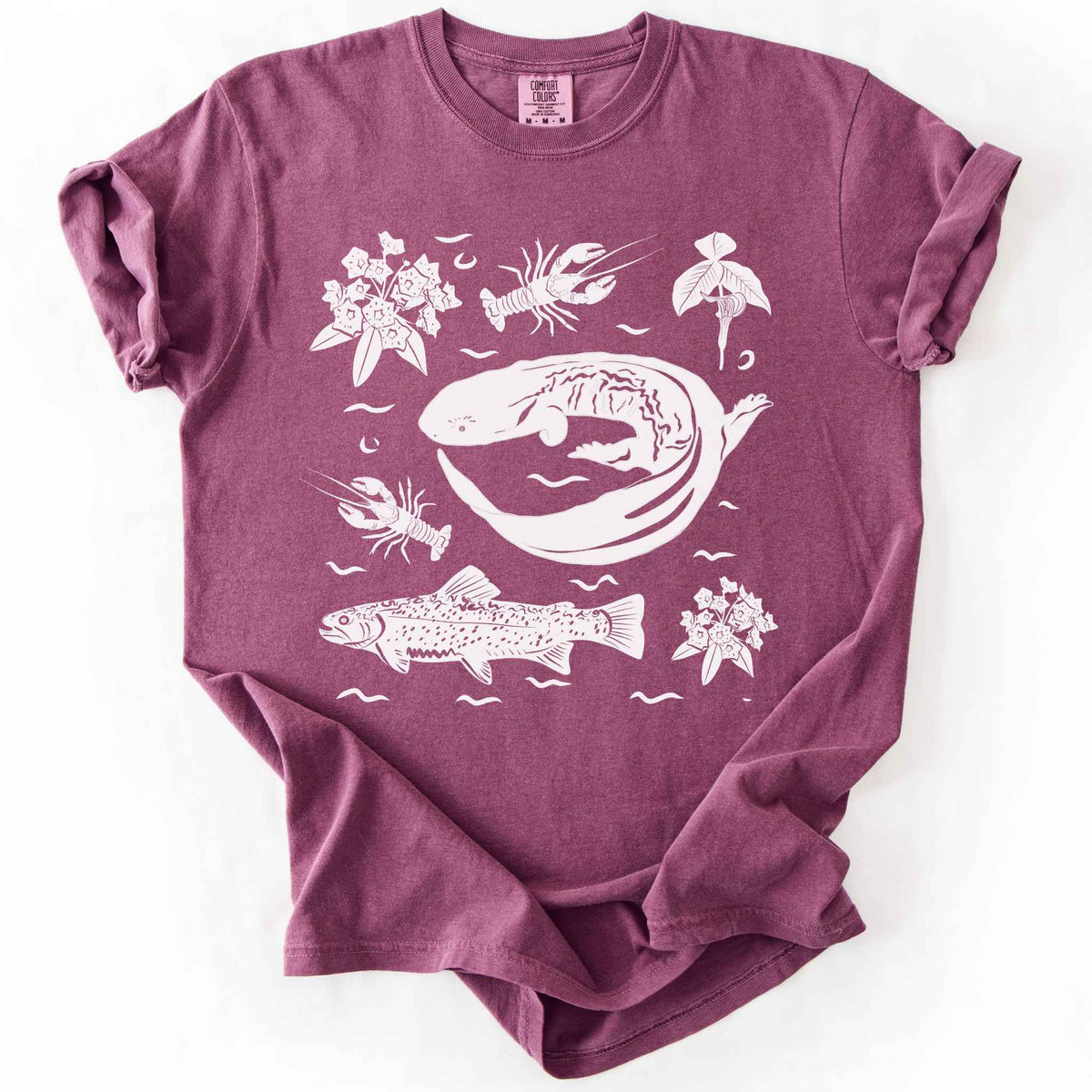 Berry "Hellbender Ecology" t-shirt on Comfort Colors tee, featuring a curled hellbender salamander surrounded by hand-drawn crayfish, trout, and mountain laurel. Amphibian and river ecosystem gift shirt for herpetology and fly fishing enthusiasts.