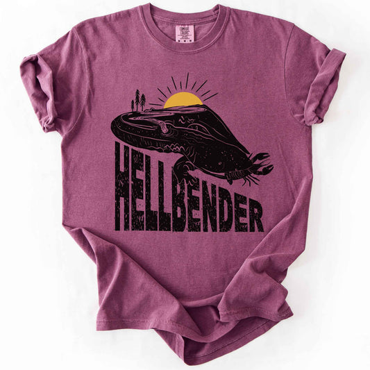 Berry "Hellbender a body of water" t-shirt on Comfort Colors tee, featuring a bold black graphic of a hellbender salamander eating a crayfish with a river landscape etched into its body. Amphibian and herpetology lover gift shirt for salamander and river conservation enthusiasts.