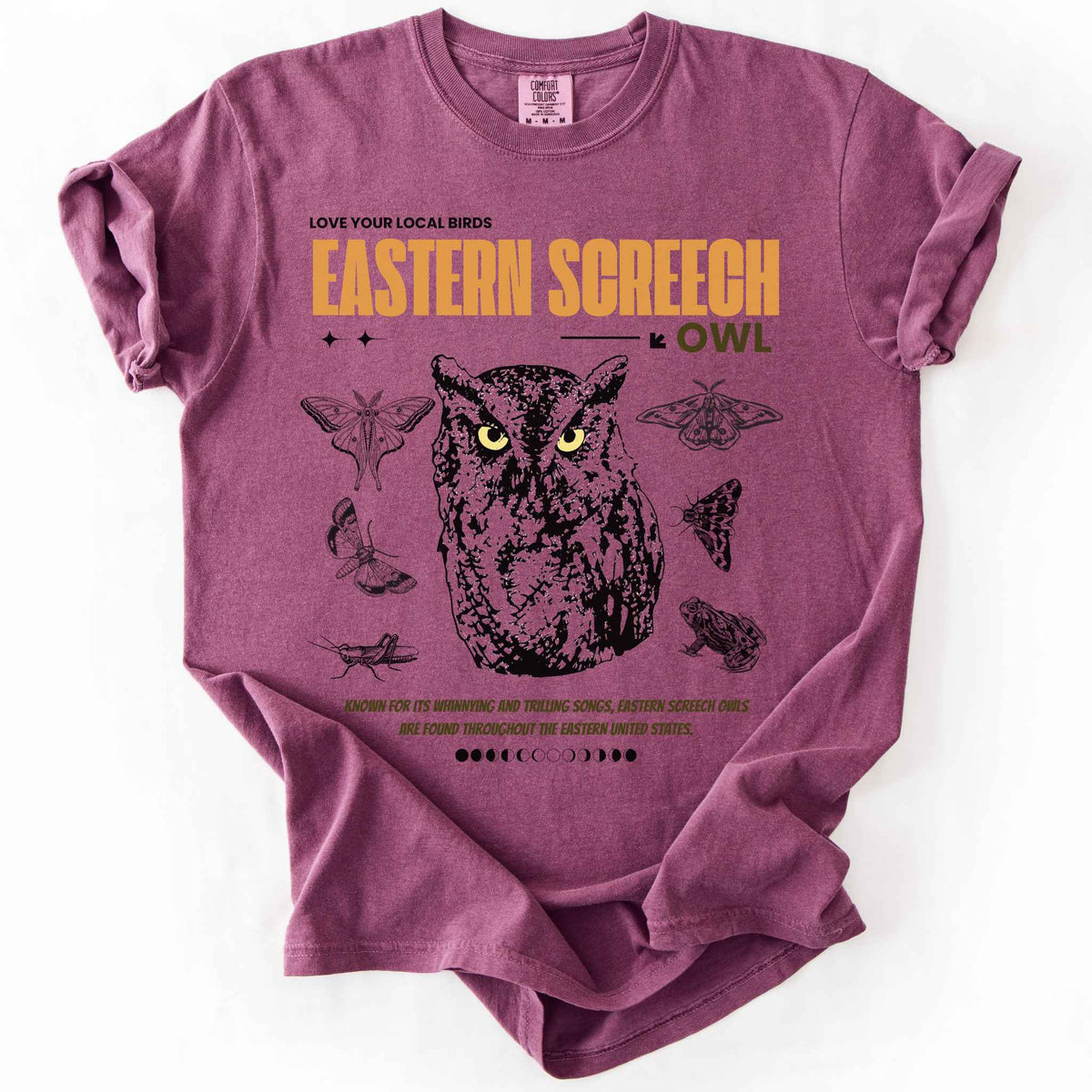 Berry "Love Your Local Birds, Eastern Screech Owl" t-shirt on Comfort Colors tee, featuring a detailed owl portrait surrounded by moths, a frog, and a grasshopper with orange lettering and educational text. Birdwatcher and owl lover gift shirt for wildlife and nature enthusiasts.