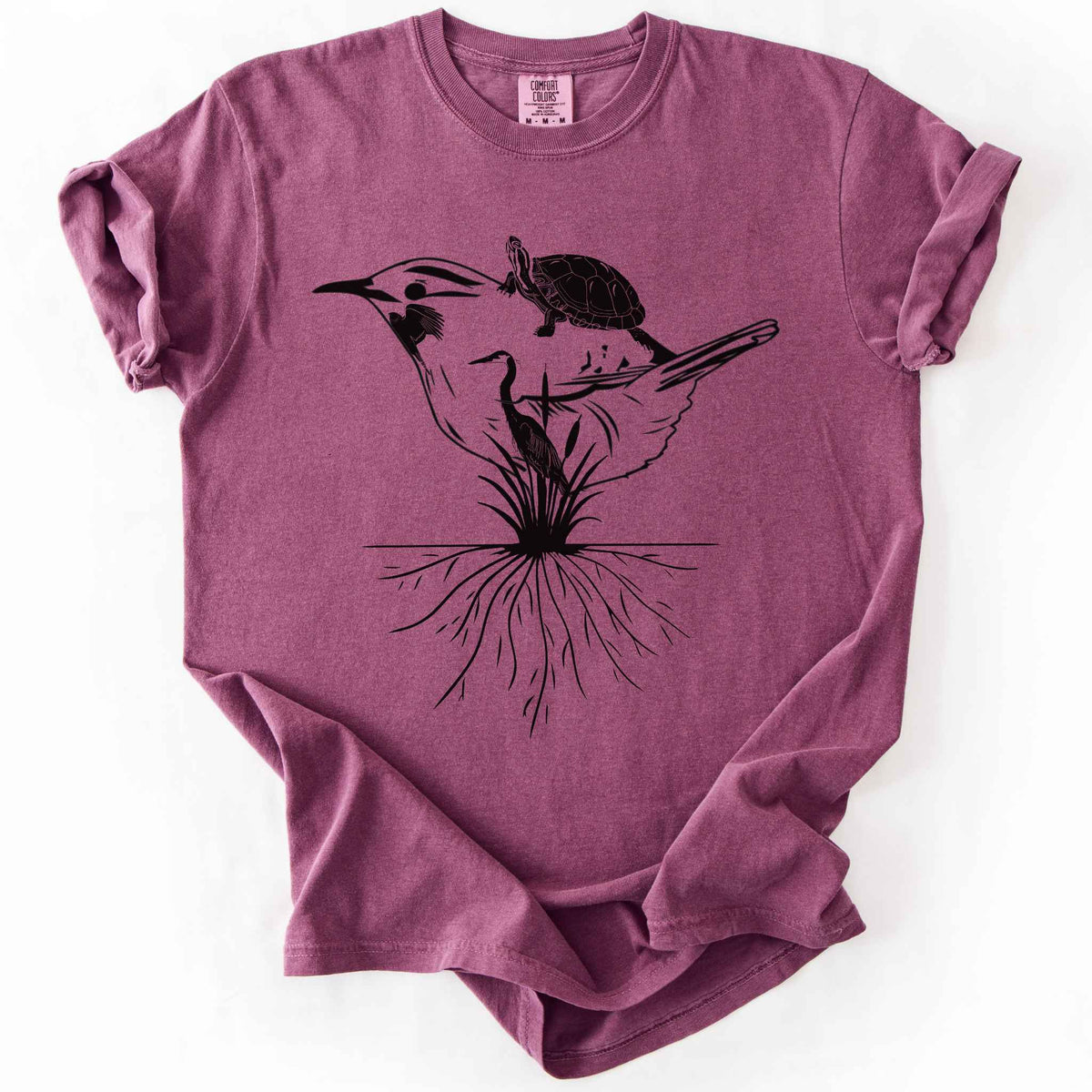 Berry "Marhlands Matter" t-shirt on Comfort Colors tee, featuring a surreal black line art style design blending a bird, turtle, heron, and cattail roots into one flowing wetland scene. Nature lover and wetland conservation gift shirt for birdwatching and wildlife enthusiasts.