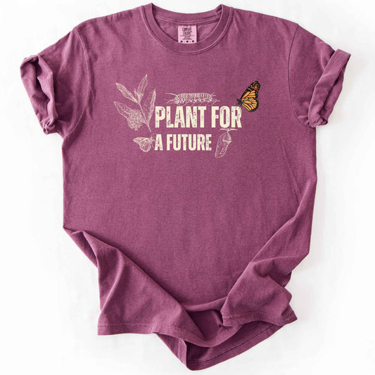 Berry "Plant for a Future" t-shirt on Comfort Colors tee, featuring the Monarch butterfly life cycle from caterpillar to chrysalis alongside milkweed graphic in cream tones. Butterfly gardener and native plant gift shirt for Monarch conservation fans.