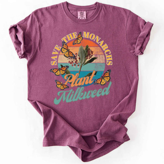 Berry "Save the Monarchs, Plant Milkweed" t-shirt on Comfort Colors tee, featuring monarch butterflies fluttering around a milkweed plant against a retro sunset design. Butterfly gardener and native plant gift shirt for Monarch conservation fans.
