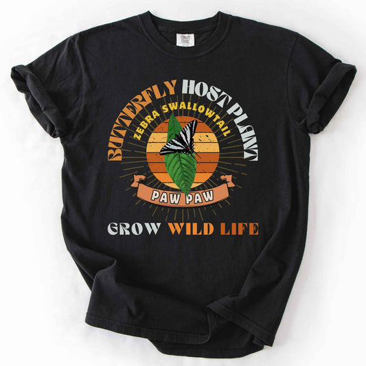 Black "Butterfly Host Plant, Zebra Swallowtail, Paw Paw, Grow Wild Life" t-shirt on Comfort Colors tee, featuring a zebra swallowtail on a pawpaw leaf against a retro sunburst design with a ribbon banner. Butterfly gardener and native plant gift shirt for pollinator and conservation enthusiasts.
