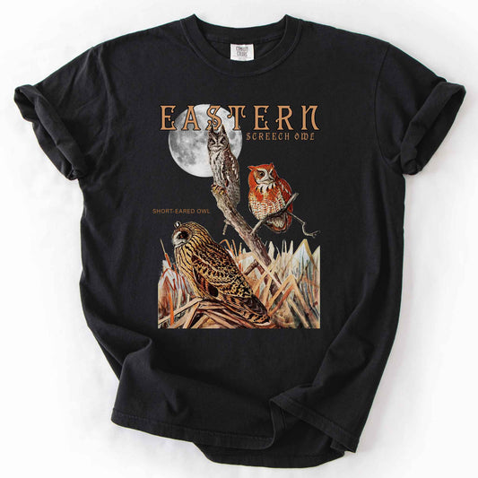Black "Eastern Screech Owl" t-shirt on Comfort Colors tee, featuring a vintage style graphic of screech owls perched under a full moon with a short eared owl in the grass below. Birdwatcher and owl lover gift shirt for wildlife and nature enthusiasts.