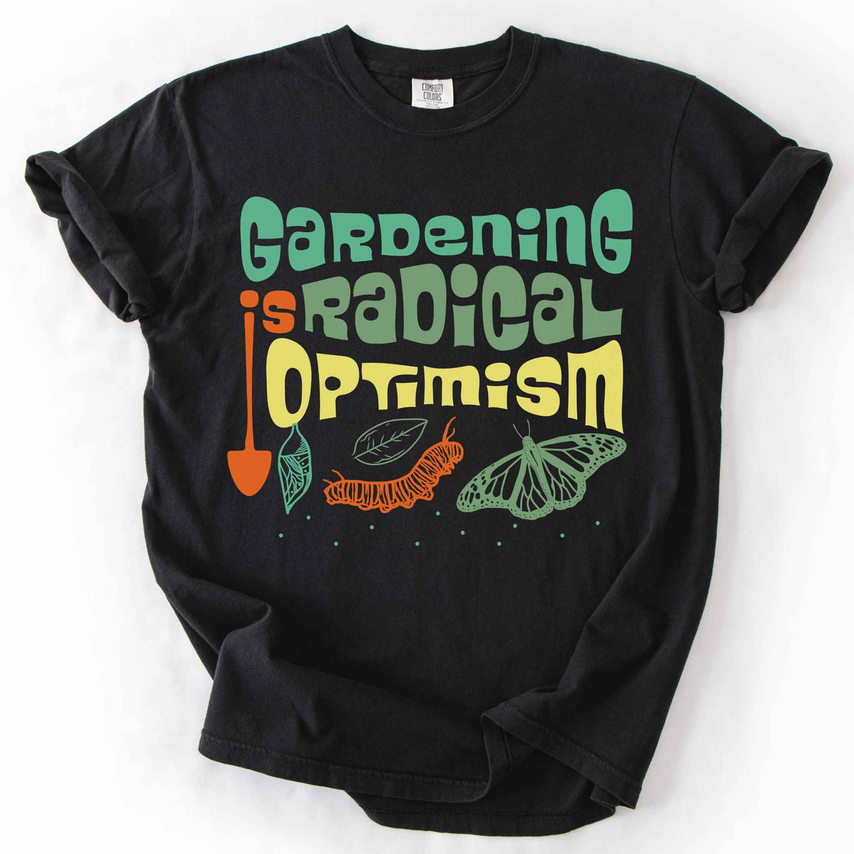 Black "Gardening Is Radical Optimism" t-shirt on Comfort Colors tee, featuring a butterfly life cycle illustration with a garden shovel and retro lettering. Gardener and native plant gift shirt for pollinator and butterfly conservation fans.