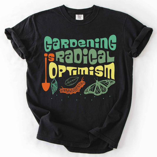 Black "Gardening Is Radical Optimism" t-shirt on Comfort Colors tee, featuring a butterfly life cycle illustration with a garden shovel and retro lettering. Gardener and native plant gift shirt for pollinator and butterfly conservation fans.
