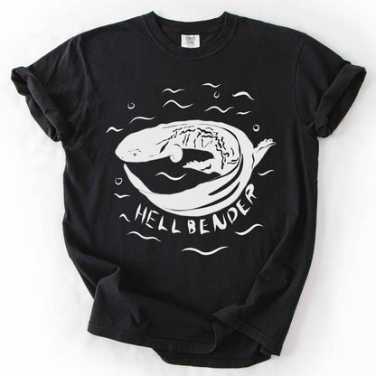 Black "Hellbender" t-shirt on Comfort Colors tee, featuring a bold graphic of a curled hellbender salamander surrounded by stylized water splashes and bubbles. Amphibian and herpetology lover gift shirt for salamander and wildlife enthusiasts.
