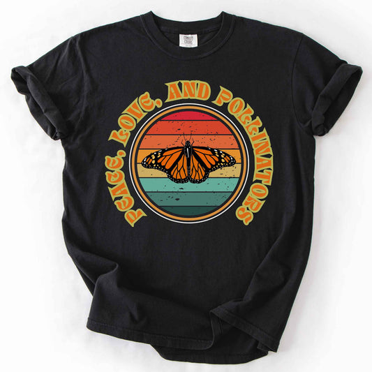 Black "Peace, Love, and Pollinators" t-shirt on Comfort Colors tee, featuring a monarch butterfly against a retro rainbow sunset circle design. Butterfly gardener and native plant gift shirt for pollinator conservation fans.
