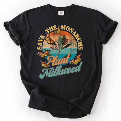 Black "Save the Monarchs, Plant Milkweed" t-shirt on Comfort Colors tee, featuring monarch butterflies fluttering around a milkweed plant against a retro sunset design. Butterfly gardener and native plant gift shirt for Monarch conservation fans.