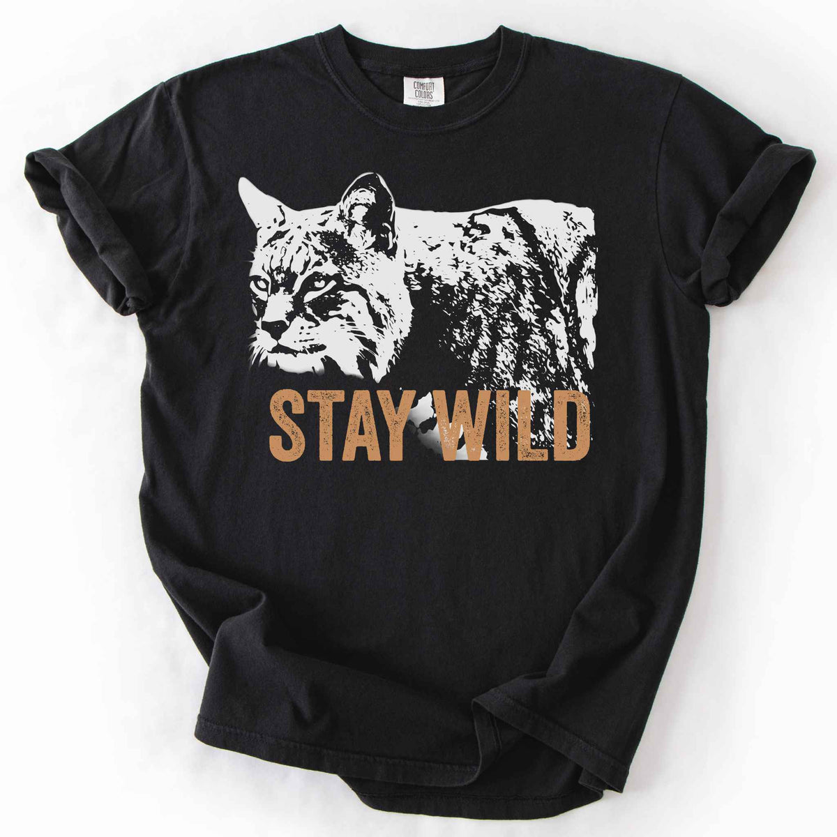 Black "Stay Wild" t-shirt on Comfort Colors tee, featuring a bold white bobcat graphic with orange lettering — wildlife lover and nature enthusiast gift shirt for outdoorsy, animal-inspired style.