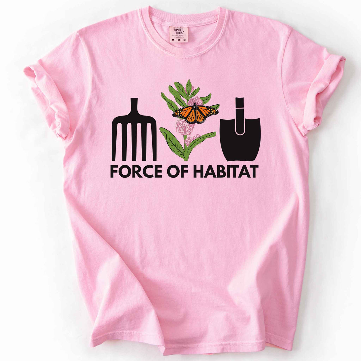 Blossom "Force of Habitat: monarch" t-shirt on Comfort Colors tee, featuring garden tool graphics flanking a hand-drawn monarch butterfly on milkweed flowers with bold black text below. Gardener and native plant gift shirt for pollinator conservation fans.
