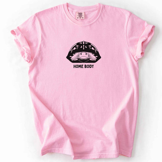 Blossom "Home Body" t-shirt on Comfort Colors tee, featuring a bold black graphic of a turtle peeking out from its shell above simple lettering. Funny turtle lover gift shirt for introverts and reptile enthusiasts.