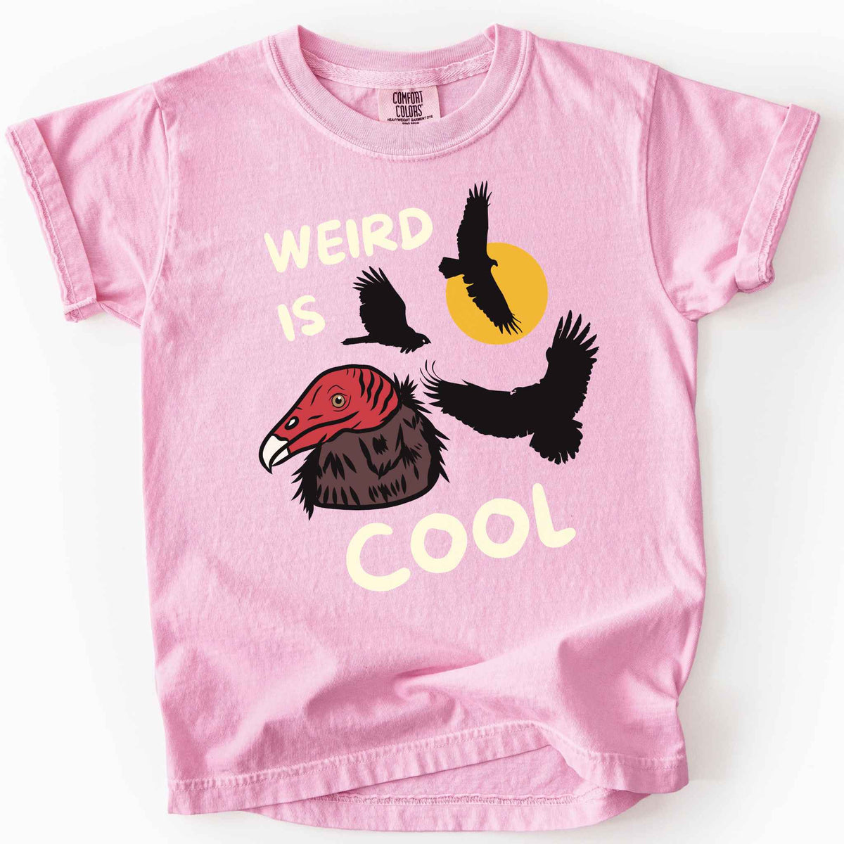 Blossom "Weird is cool" kids t-shirt on comfort colors tee featuring turkey vulture silhouettes and a hand-drawn profile graphic with bold white playful text. Gift for little beginning birders and wildlife enthusiasts. 