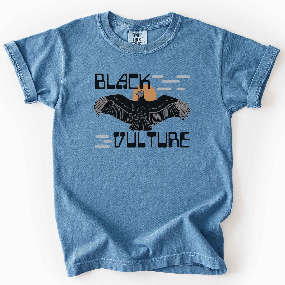 Blue jean "Black Vulture" kids t-shirt on Comfort Colors tee, featuring a vulture with spread wings against an orange sun with bold geometric lettering. Birdwatcher and scavenger lover gift shirt for wildlife and nature enthusiasts.