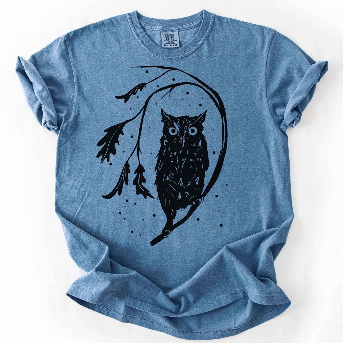 Blue jean "Eastern Screech starry night" owl t-shirt on Comfort Colors tee, featuring a bold black illustration of a screech owl perched on a leafy branch with scattered dots for stars. Birdwatcher and owl lover gift shirt for wildlife and nature enthusiasts.