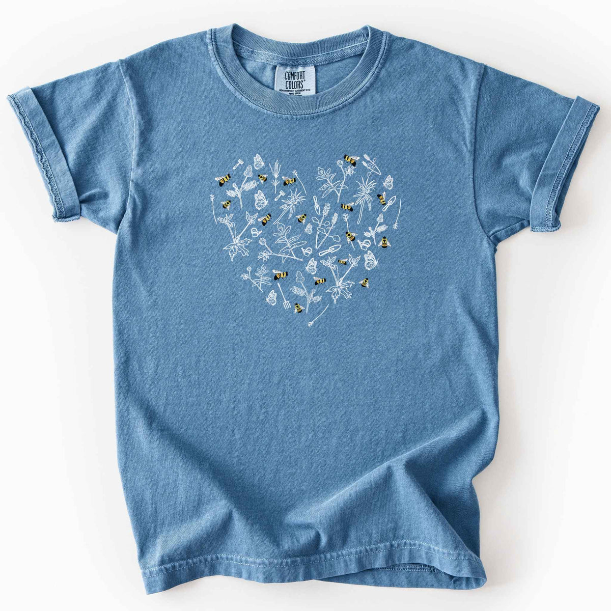Blue jean "Rusty Patch Bumblebee" kids t-shirt on Comfort Colors tee, featuring a heart shaped arrangement of hand-drawn white wildflowers, garden tools, butterflies, and colorful bees. Gardener and pollinator lover gift shirt for bee conservation and nature enthusiasts.