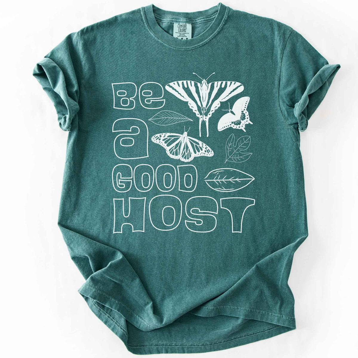 Blue spruce "Be a good host" t-shirt on Comfort colors with illustrations of zebra swallowtail and host plant paw paw leaf, spicebush swallowtail and one of its host plants sassafras leaf, and monarch and host plant milkweed leaf. Gift for wildlife gardeners and native plant enthusiasts.