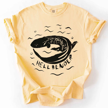 Butter "Hellbender" t-shirt on Comfort Colors tee, featuring a bold graphic of a curled hellbender salamander surrounded by stylized water splashes and bubbles. Amphibian and herpetology lover gift shirt for salamander and wildlife enthusiasts.