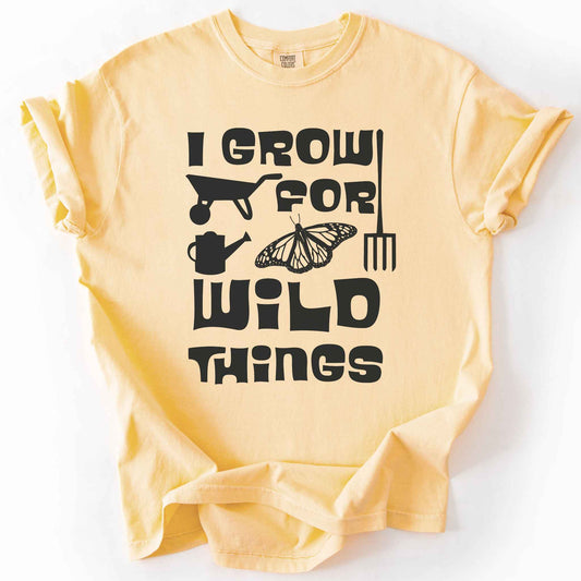 Butter "I Grow for Wild Things" t-shirt on Comfort Colors tee, featuring a monarch butterfly with garden tool icons and bold black lettering text. Gardener and native plant gift shirt for pollinator conservation fans.