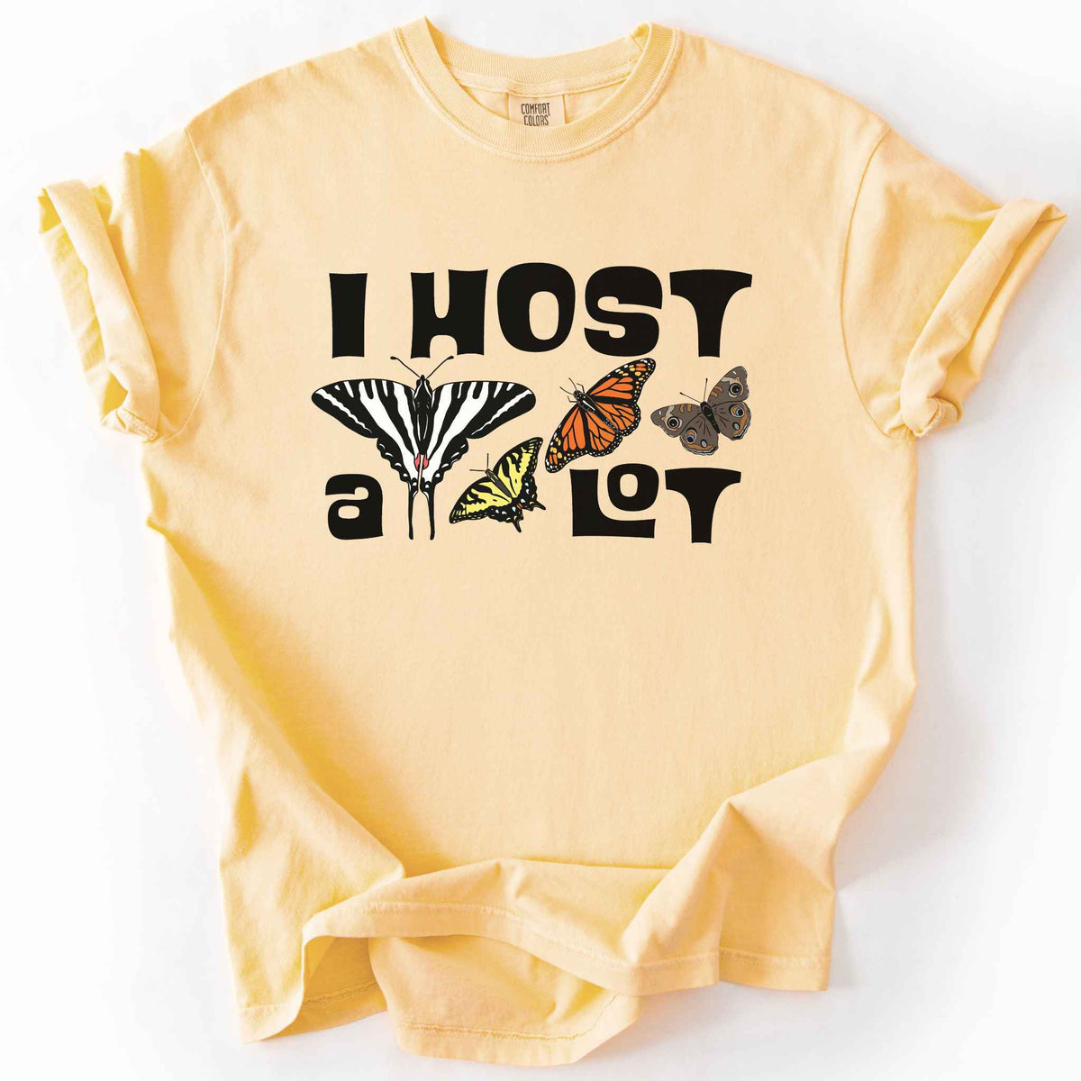 Butter "I Host a Lot" t-shirt on Comfort Colors tee, featuring four butterfly species graphics including a Zebra Swallowtail and Monarch with bold black lettering text. Funny gardener and butterfly host plant gift shirt for pollinator enthusiasts.