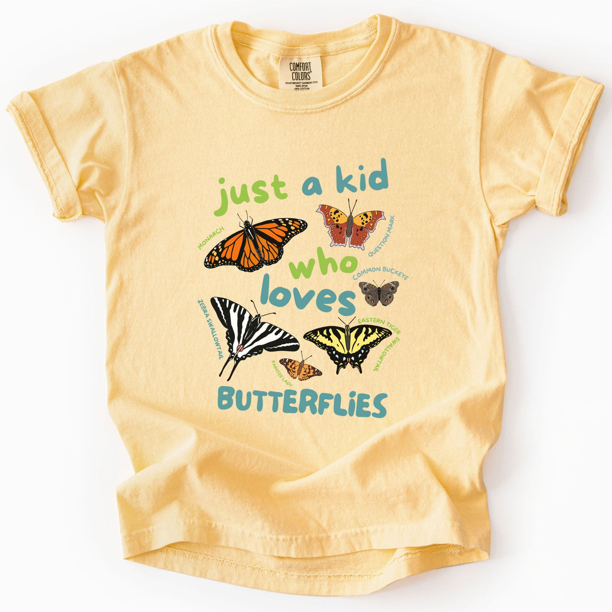 Butter "Just a Kid Who Loves Butterflies" youth t-shirt on Comfort Colors tee, featuring six labeled butterfly species including Monarch, Zebra Swallowtail, and Painted Lady with playful green and teal lettering. Kids butterfly lover gift shirt for young nature explorers and budding entomologists.