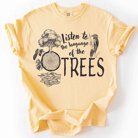 Butter "Listen to the Language of the Trees" t-shirt on Comfort Colors tee, featuring a tree, tree rings, woodpecker, cicada, and mushrooms in white. Nature lover and forest ecology gift shirt for tree huggers and outdoor enthusiasts.