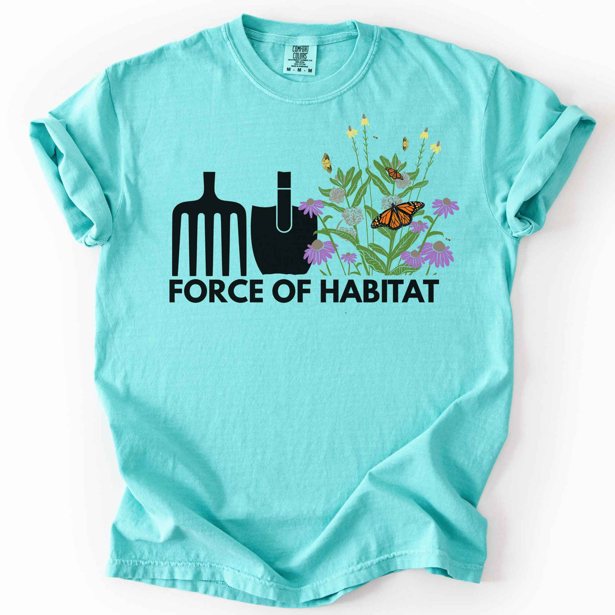 Chalky mint "Force of Habitat" t-shirt on Comfort Colors tee, featuring simple garden tool graphics beside a coneflower and milkweed patch with monarch and fritillary butterflies. Gardener and native plant gift shirt for pollinator conservation fans.