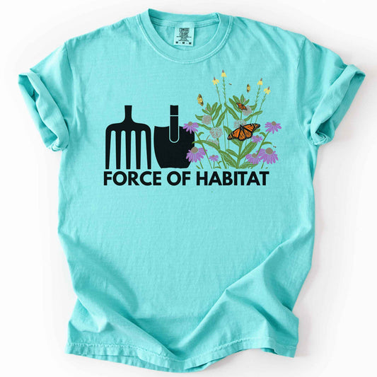 Chalky mint "Force of Habitat" t-shirt on Comfort Colors tee, featuring simple garden tool graphics beside a coneflower and milkweed patch with monarch and fritillary butterflies. Gardener and native plant gift shirt for pollinator conservation fans.