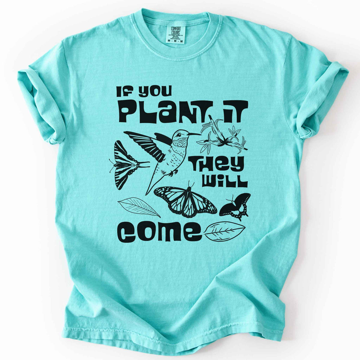 Chalky mint "If You Plant It, They Will Come" t-shirt on Comfort Colors tee, featuring a hummingbird surrounded by butterflies and flowers with bold black lettering and line art style. Gardener and native plant gift shirt for pollinator conservation fans.