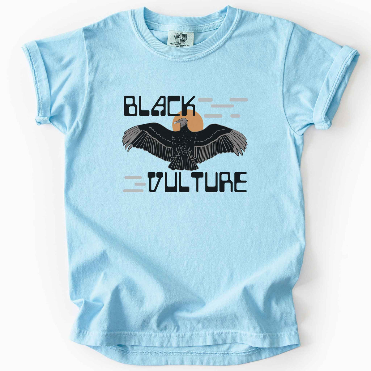Chambray "Black Vulture" kids t-shirt on Comfort Colors tee, featuring a vulture with spread wings against an orange sun with bold geometric lettering. Birdwatcher and scavenger lover gift shirt for wildlife and nature enthusiasts.